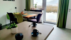 A dining area with a table, chairs, and a view of a snowy landscape through a window. - "Little time out" - fantastic view of the Franconian countryside - ideal for bikers. (Scheßlitz)