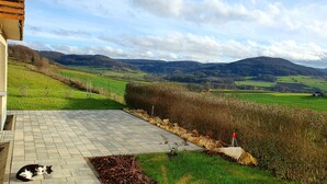 A paved patio with a view of rolling hills and a hedge. - "Little time out" - fantastic view of the Franconian countryside - ideal for bikers. (Scheßlitz)