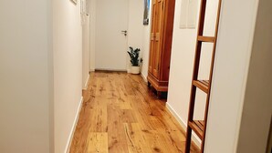 A hallway with wooden flooring, white walls, and a wooden cabinet. - "Little time out" - fantastic view of the Franconian countryside - ideal for bikers. (Scheßlitz)
