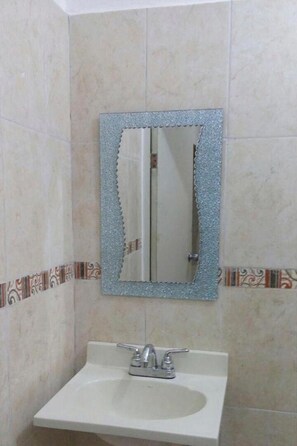 A bathroom with a sink, a mirror, and tiled walls. - OYO Hotel Puerto Real Minatitlán (Minatitlán)