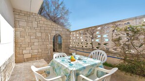 A patio with a table and chairs, a stone wall, and a decorative metal fence. - 2834 Sun&sea by Barbarhouse (Lecce)