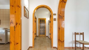 A hallway with wooden arches, a tiled floor, and a door at the end. - 2834 Sun&sea by Barbarhouse (Lecce)