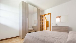 A bedroom with a bed, a wardrobe, a mirror, and a dresser. - 2834 Sun&sea by Barbarhouse (Lecce)