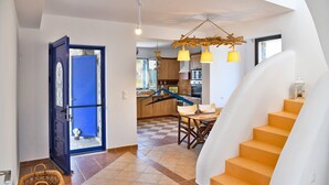 Una cocina amplia con electrodomésticos modernos, un comedor con mesa de madera y una escalera con un diseño único.