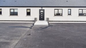 A building with a flat roof, a black door, and multiple windows.