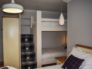 Habitación con literas, armario y escalera.