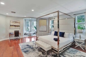 A modern bedroom with a four-poster bed, a desk, and a large window. - Resort Villa Compound 7BR 2 Houses In One HTD Pool (Pompano Beach)