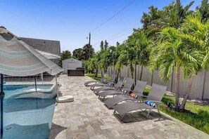 A poolside area with lounge chairs and a covered seating area. - Resort Villa Compound 7BR 2 Houses In One HTD Pool (Pompano Beach)