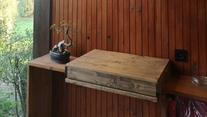 Paret de fusta amb un llum penjada i una taula petita amb una planta.