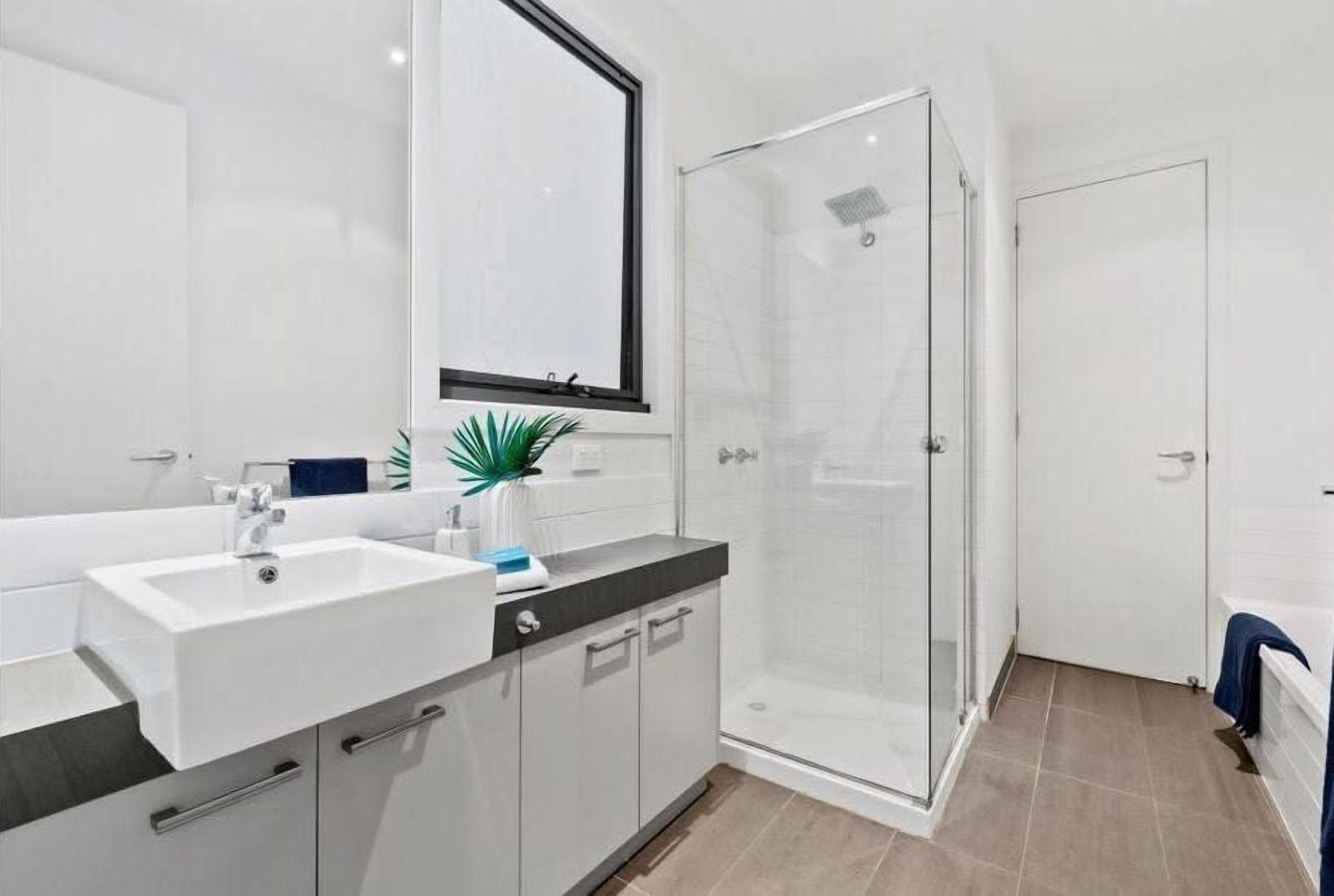 Ein modernes Badezimmer mit Waschbecken, Spiegel und Dusche.