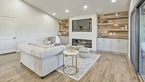 A modern living room with a fireplace, a sofa, a coffee table, and a rug. - Broadmoor Luxury Retreat - Mountain View & Hot Tub (Colorado Springs)