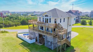 Una casa de dos pisos con balcón, piscina y terraza.
