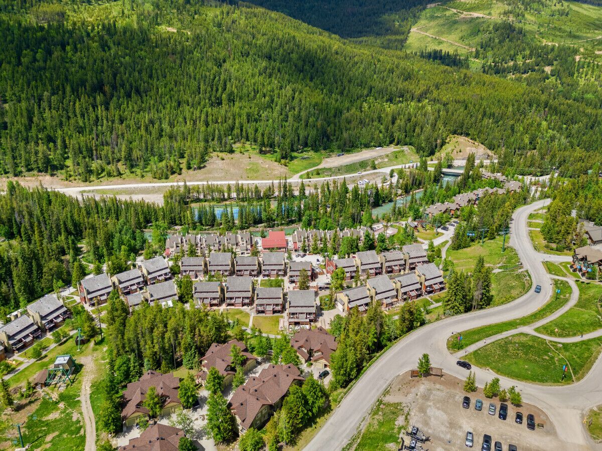 An aerial view of a residential area with multiple buildings, roads, and a river.