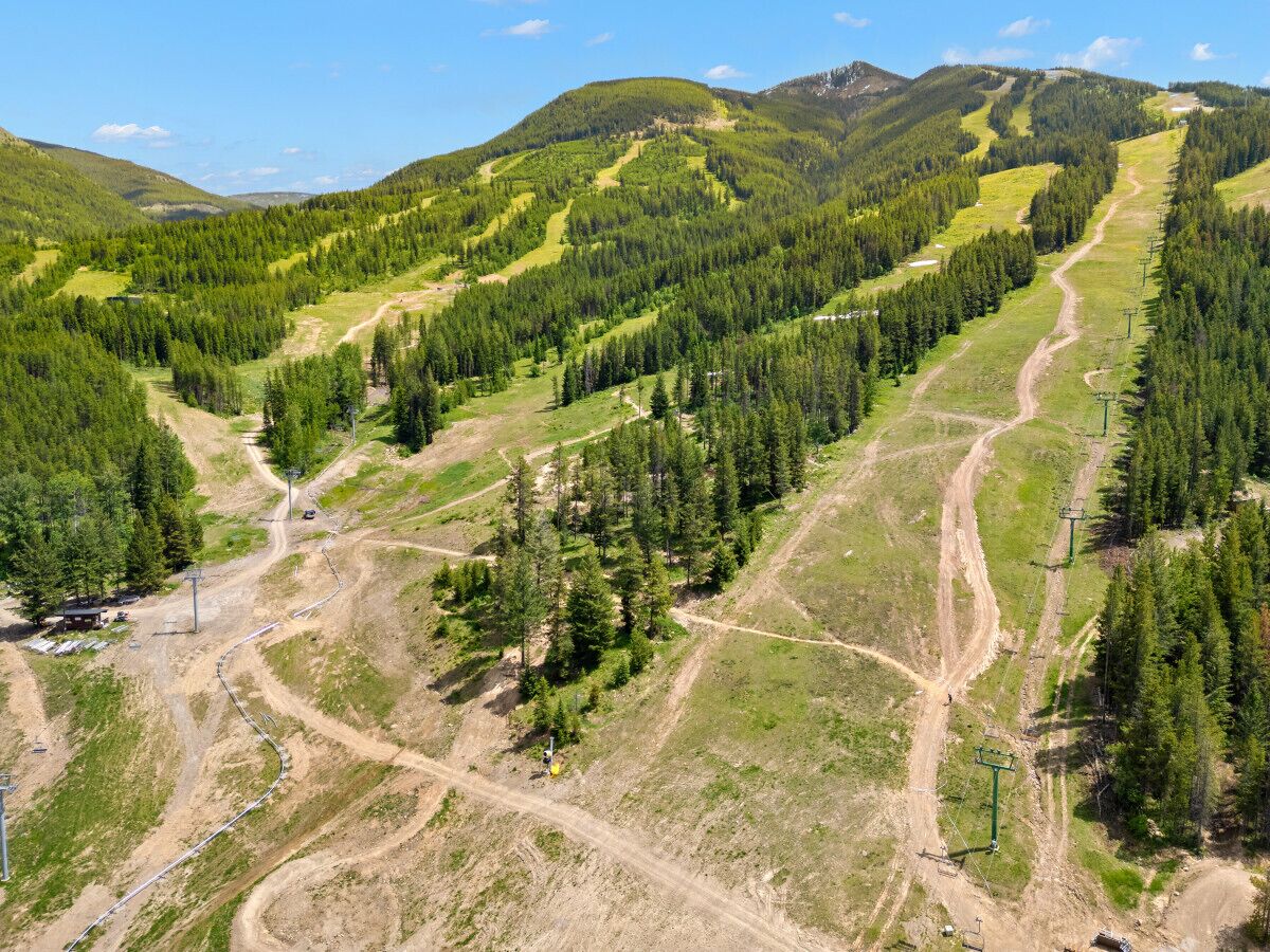 A mountainous landscape with winding roads and dense forests.