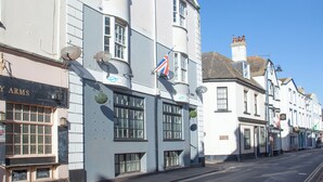 Uma fileira de edifícios brancos com várias janelas e bandeiras, incluindo a bandeira britânica.