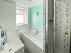 A bathroom with a bathtub, a shower, and a window. - 2 bedroom accommodation in Levens, near Kendal (Levens, near Kendal)