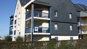 A multi-story building with balconies, a visible sign, and a clear sky. - Arzon au balcon - Port du Crouesty (Arzon)