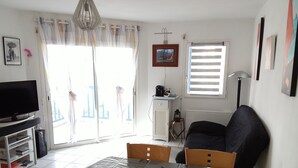 A modern living room with a dining table, a TV, and a sofa. - Arzon au balcon - Port du Crouesty (Arzon)