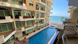 A multi-story hotel with a pool and balconies overlooking the sea. - Condos Tiara (Mazatlán)