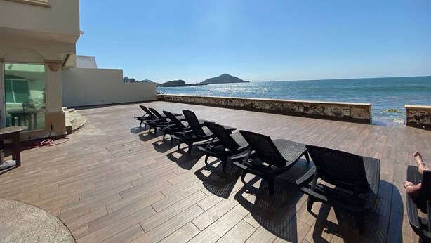 A rooftop terrace with sun loungers facing a sea view. - Condos Tiara (Mazatlán)