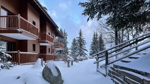 A snow-covered pathway leading to a wooden building with balconies. - ARCS 1800 COSY SKI-IN/SKI-OUT APARTMENT IN A LUXURY CHALET (Bourg Saint Maurice)