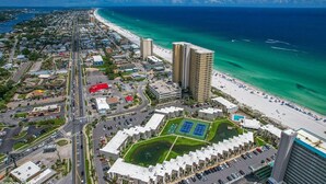 An aerial view of a coastal city with a beach, high-rise buildings, and a sports complex. - Beach Chairs For 4 • 1st Floor • Sleeps 6 (Panama City Beach)