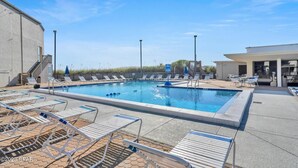 A swimming pool with lounge chairs and a covered seating area. - Beach Chairs For 4 • 1st Floor • Sleeps 6 (Panama City Beach)