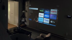 Ein Wohnzimmer mit Wand-Fernseher, der verschiedene Streaming-Dienste anzeigt.