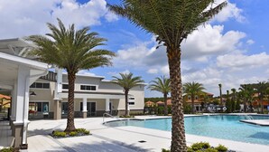 A modern hotel with a swimming pool, palm trees, and a clear blue sky. - Serenity By Your Private Pool! Excellent Reviews! Resort Living! 4450 (Kissimmee)