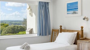 A bedroom with a wooden bed, a window with a view of greenery, and a framed picture on the wall. - Spacious Apartment in Rock, Private Parking (Rock)