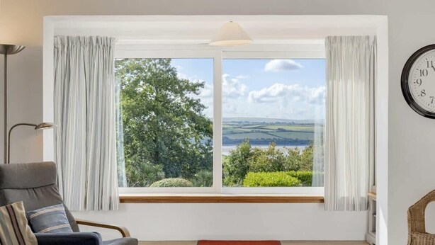 A room with a large window offering a scenic view of greenery and hills. - Spacious Apartment in Rock, Private Parking (Rock)