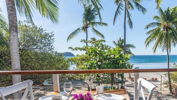 Mesa para dos personas con vista a la playa y al océano.
