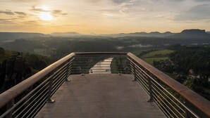 A panoramic view from a high vantage point overlooking a valley with a river, distant mountains, and a small town. - Vacation apartment in a renovated monument (max. 5 persons) (Bischofswerda)