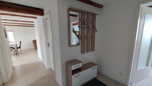 A room with a wooden floor, a white wardrobe, a black doormat, and a mirror with wooden frames. - Vacation apartment in a renovated monument (max. 5 persons) (Bischofswerda)