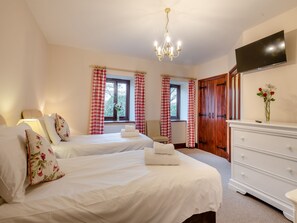 A hotel room with two beds, a chandelier, a TV, and a dresser. - 5 bedroom accommodation in Sculthorpe, Fakenham (Sculthorpe, Fakenham)