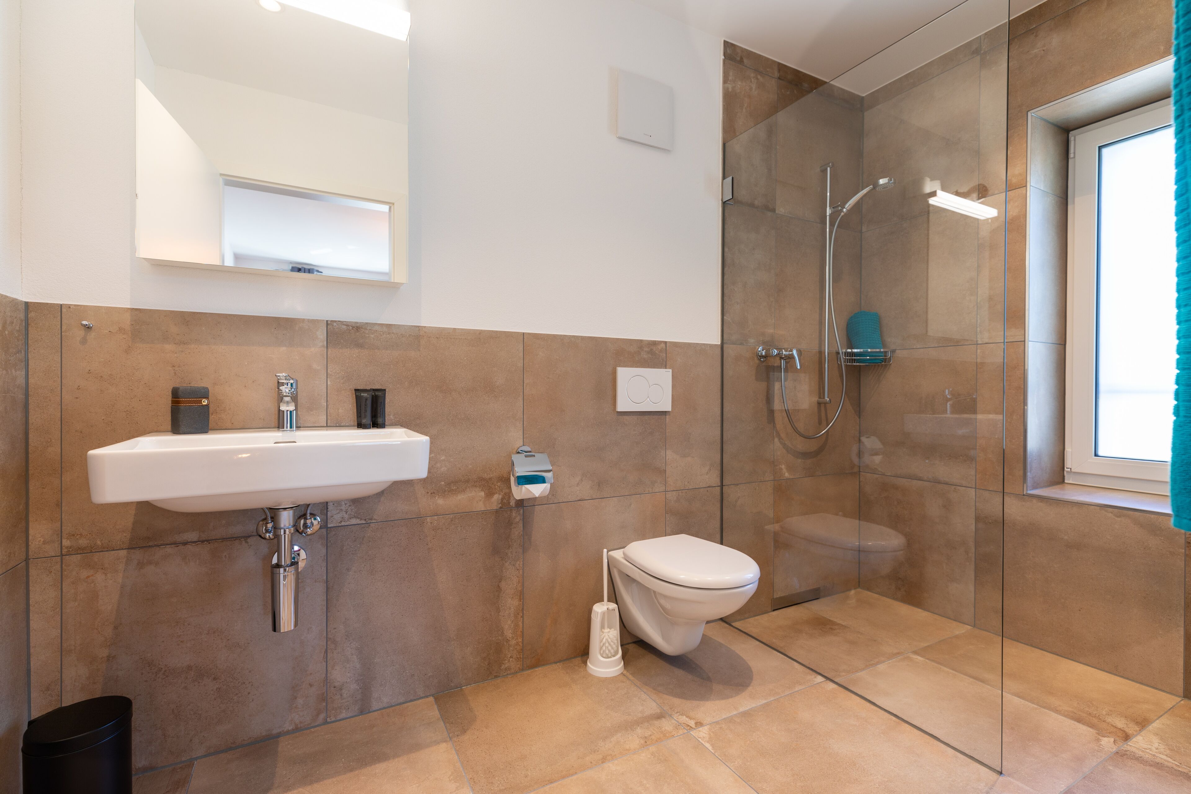 Une salle de bain moderne avec un lavabo, des toilettes et une douche à parois de verre.