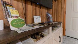 Ein Empfangsschalter mit Holzwand, mit einem Schild für 'New River Gorge, West Virginia' sowie verschiedenen Büchern und Zeitschriften.