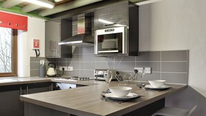 Uma cozinha moderna com ilha central, eletrodomésticos de aço inoxidável e uma janela com vista.