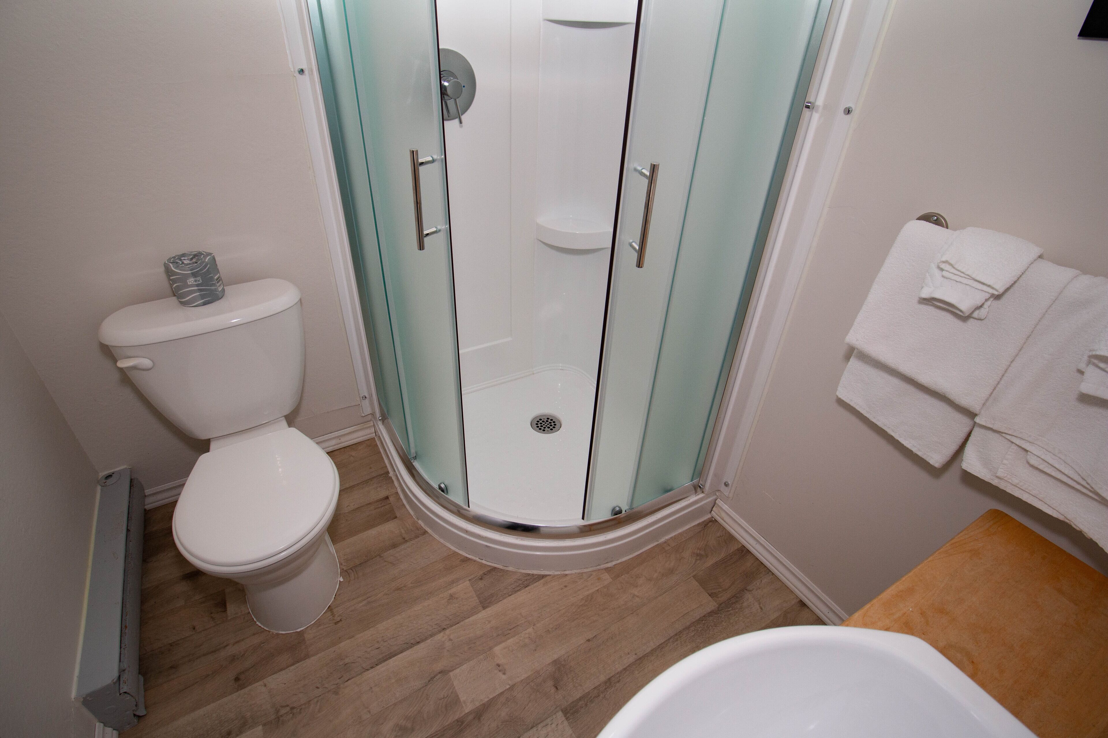 A bathroom with a glass-enclosed shower, a toilet, and a bathtub.