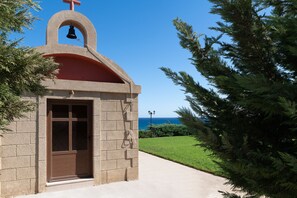 Une petite église dotée d’un clocher, d’une porte et offrant une vue sur l’océan.
