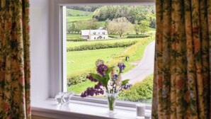 A window with a view of a rural landscape, including a house and fields. - 3 bedroom accommodation in Girvan (Girvan)