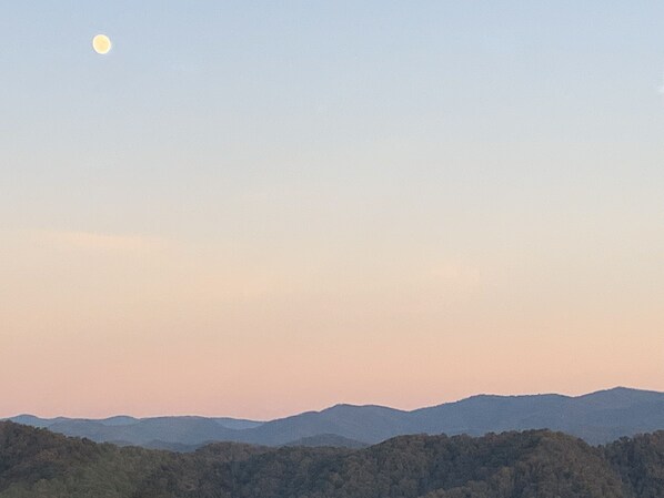 A landscape with a crescent moon and a range of hills.