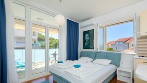 A bedroom with a bed, a window, a balcony, and a view of the outside. - Studio LINO in Solitudo (Dubrovnik)