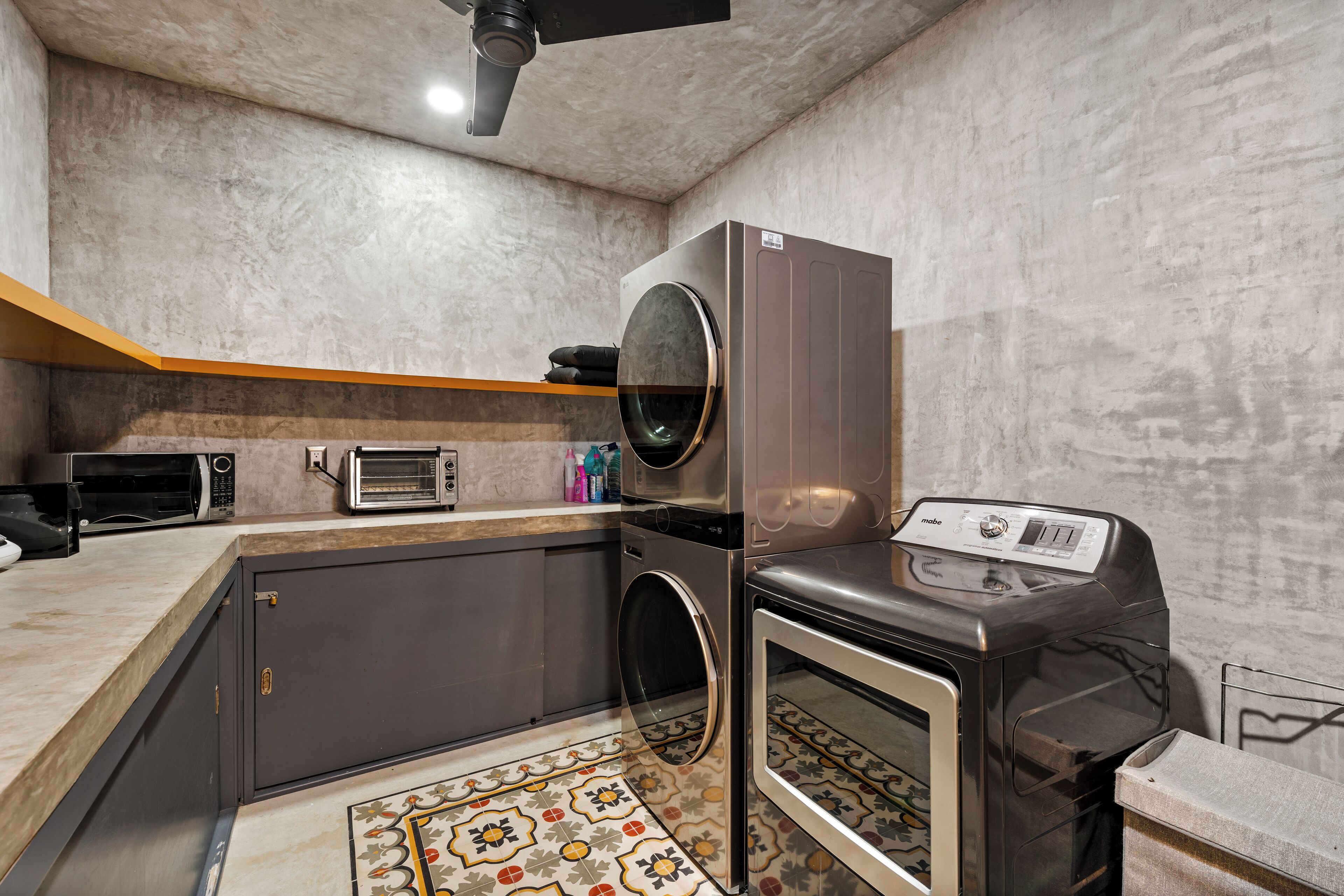 A compact kitchen with a built-in washer, a microwave, a toaster, and a small oven.