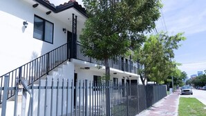 A two-story building with a white facade and black railings.