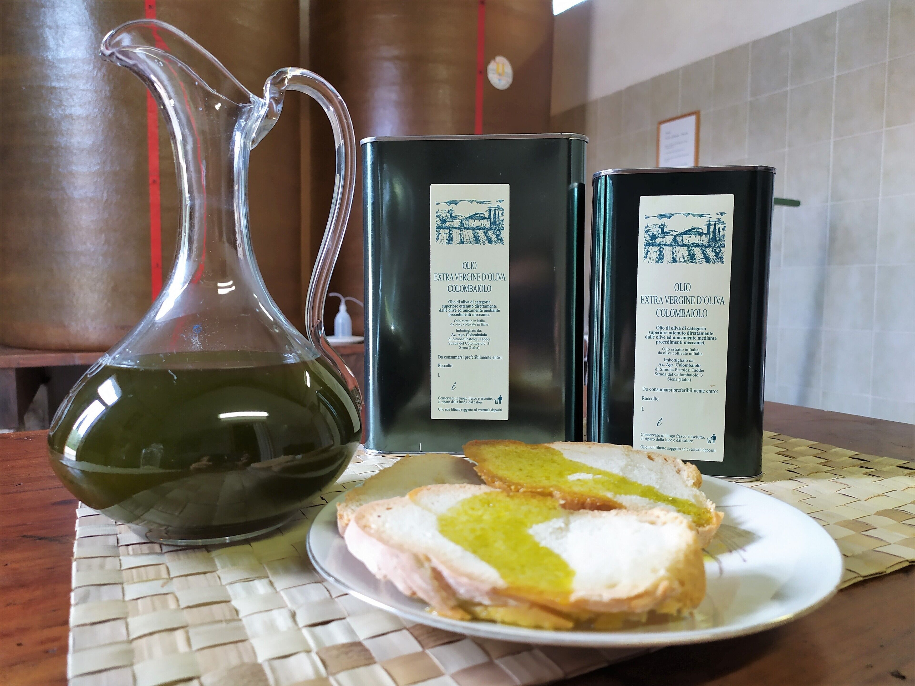 Una botella de aceite de oliva virgen extra, dos cajas con información de producto y un plato con un sándwich.