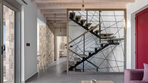 A modern interior with a staircase, a wooden table with a book, and a red door. - Southrock Villas - 6 Bed Magnificent Seaview Villa with Private Pool New Listing (Lachania)