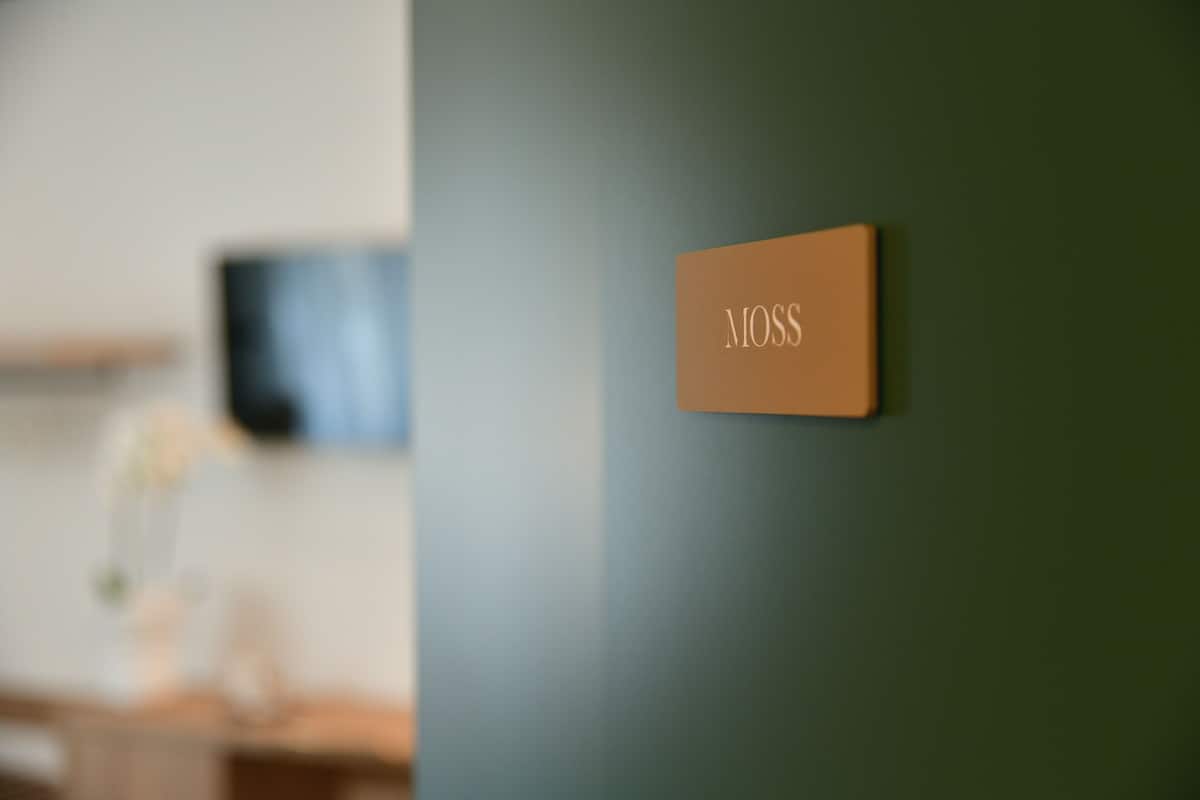 A room with a green wall and a sign that reads "MOSSS".
