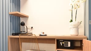 A compact kitchen with a wooden countertop, a built-in microwave, a small refrigerator, and a chair. - Dimora al castello (Matera)