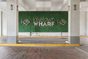 A parking garage entrance with a green wall displaying the text 'Jaketown WHARF' and two fish symbols.